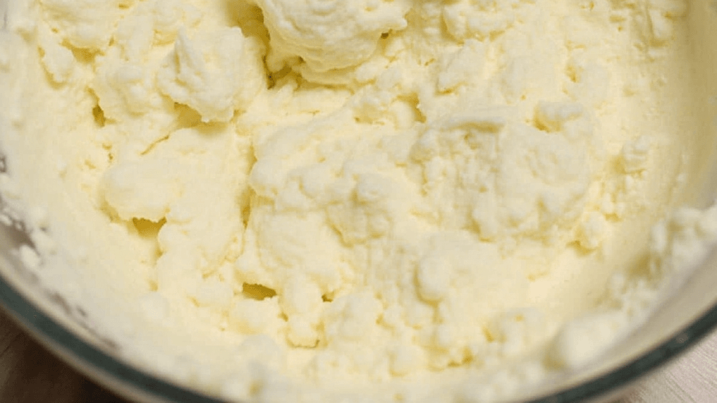 Philadelphia cream cheese filling in a bowl with a spatula, ready for cakes and pastries.